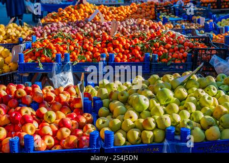 Una varietà di frutta è esposta in casse blu, tra cui mele e arance. La scena è vivace e colorata, con i frutti disposti in un appea Foto Stock