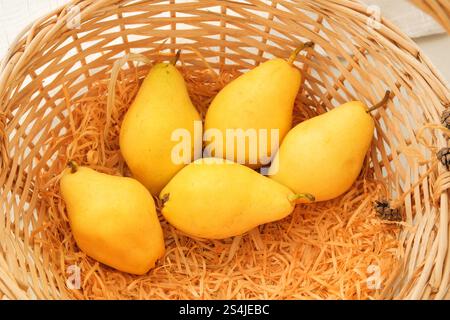 Pere in un cestello di paglia. Frutta gialla matura. Le pere sono costituite da un gran numero di vitamine e sostanze nutritive. Vista dall'alto. Foto Stock