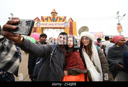 PRAYAGRAJ, INDIA - 12 GENNAIO 2025: Turisti stranieri che visitano il Mahakumbh Nagar a Prayagraj, India. Il prossimo Maha Kumbh Mela si svolgerà a Prayagraj dal 13 gennaio al 26 febbraio 2025. Si prevede che il festival attirerà oltre 400 milioni di pellegrini. Il Maha Kumbh Mela è un raduno spirituale che comprende santi, eremiti, pellegrini e altri provenienti da tutti i ceti sociali. La festa è incentrata sul rituale di fare un tuffo sacro nell'acqua Santa, che simboleggia la purificazione spirituale. (Foto di Deepak Gupta/Hindustan Times/Sipa USA ) Foto Stock