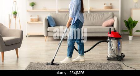 Donna pulizia casa, cantando e utilizzando hoover Foto Stock
