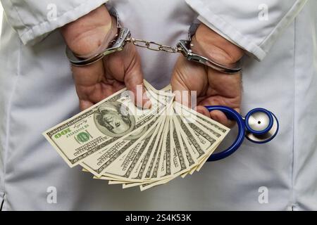 Un medico con banconote e manette da dollaro, Austria, Europa Foto Stock