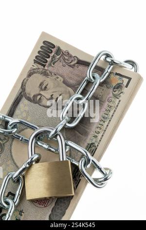 Banconote in yen giapponesi con serratura e catena. Un insieme di soldi per la sicurezza e gli investimenti Foto Stock