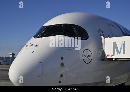 Lufthansa Airbus A350-900, cabina di pilotaggio e cabina con ponte di imbarco passeggeri al momento del check-in di fronte al Terminal 2 con cielo blu, Apron 2 East, T Foto Stock