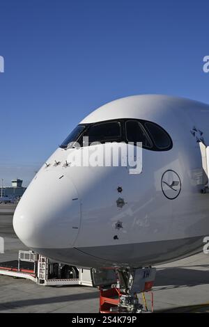 Lufthansa Airbus A350-900, cabina di pilotaggio e cabina con ponte di imbarco passeggeri al momento del check-in di fronte al Terminal 2 con cielo blu, Apron 2 East, T Foto Stock