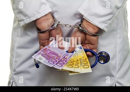 Un medico con banconote e manette in euro, Austria, Europa Foto Stock