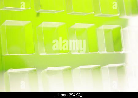 Uno stampo per termoformatura quadrato trasparente industriale realizzato in plastica come soluzione di imballaggio per prodotti industriali. Vassoio in alluminio su sfondo verde. Foto Stock