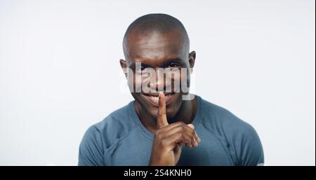 Studio, ritratto e uomo nero con segreto fitness per la salute, il benessere e l'allenamento felice in palestra. Privacy, pettegolezzi e personal trainer con sorriso Foto Stock