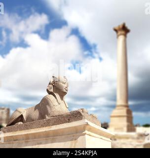 Famoso punto di riferimento - Serapeo di Alessandria. Sfinge e pilastro di Pompeo ad Alessandria, Egitto, Nord Africa. Tempio romano Serapeo con il pilastro di Pompeo e Foto Stock