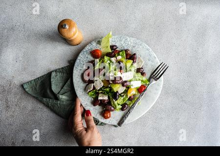 Una vivace insalata greca con pomodori, lattuga, olive fermentate e formaggio feta Foto Stock