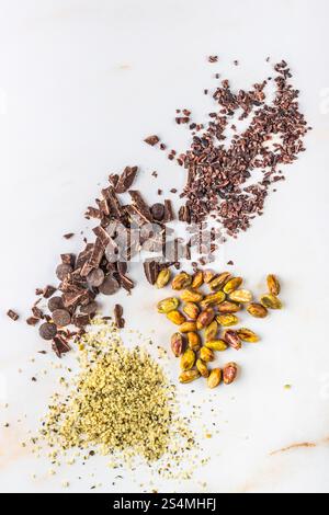Cioccolato fondente, pennini di cacao con pistacchio e semi di canapa per una cottura e una cottura salutari Foto Stock