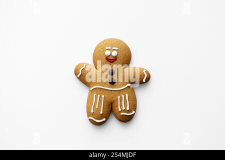 Un delizioso biscotto uomo di pan di zenzero decorato con glassa, sorridente su sfondo bianco, perfetto per temi di vacanza, cottura e festività Foto Stock