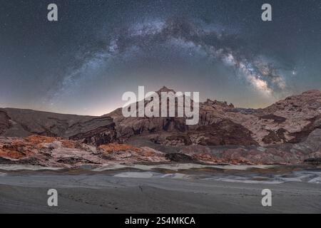 Una vista panoramica mozzafiato della via Lattea che si estende sugli aspri paesaggi del deserto dello Utah, sotto un cielo stellato. Foto Stock