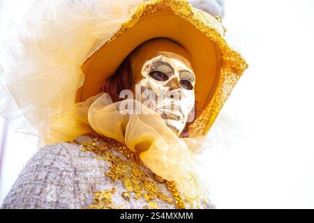 Costume di carnevale veneziano: Donna caucasica mascherata dorata in ela Foto Stock