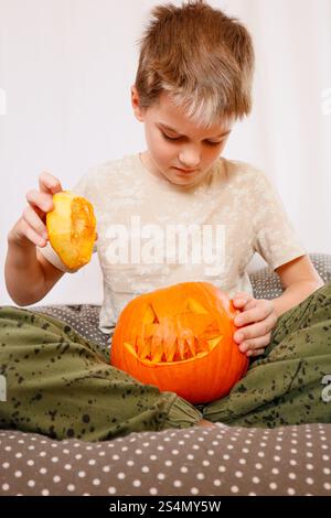 Ragazzo che gioca con una zucca intagliata Foto Stock