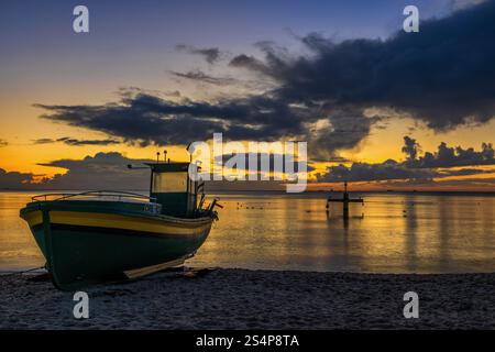 Il Mar Baltico con barca da pesca su una spiaggia all'alba a Gdynia, Polonia. Foto Stock
