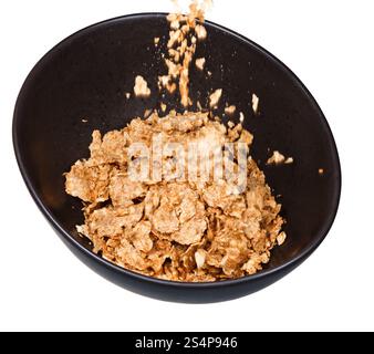 versamento di cereali in un recipiente scuro isolato su sfondo bianco Foto Stock