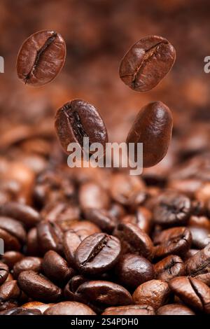 4 La caduta di fagioli e buio chicchi di caffè tostati lo sfondo con il primo piano di messa a fuoco Foto Stock