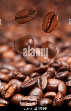 4 La caduta di chicchi di caffè e caffè torrefatto in background con la messa a fuoco in primo piano Foto Stock