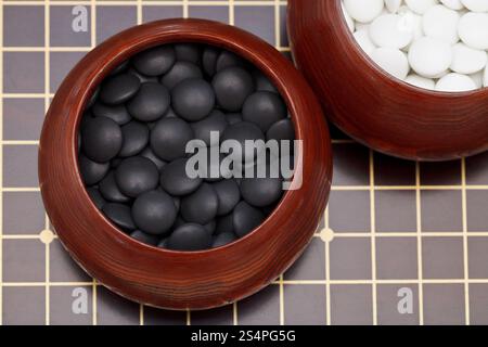 Nero doppio yunzi convessa pietre in ciotola di legno su tavola Foto Stock