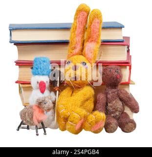 Feltro giocattoli morbidi vicino a pila di libri isolati su sfondo bianco Foto Stock