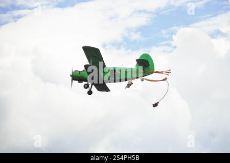 salta in paracadutismo da piccoli aerei verdi in nuvole bianche Foto Stock