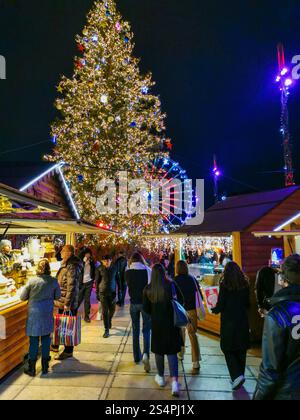 I visitatori passeggiano attraverso il vivace mercato di Natale in Place de Jaude a Clermont-Ferrand, ammirando le decorazioni e gustando le prelibatezze natalizie. Foto Stock