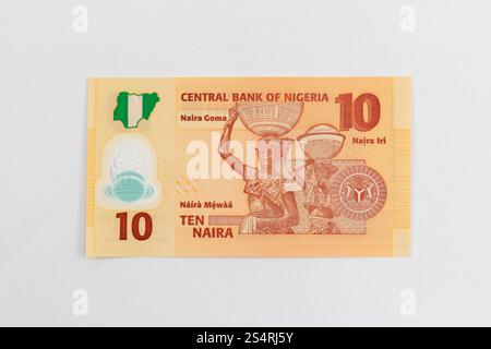 Sul retro della banconota da dieci naira nigeriane, due donne che trasportano calabroni in cima alla testa, emblematica della cultura nigeriana settentrionale Foto Stock