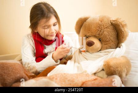 Poco carino ragazza giocare in ospedale con Teddy bear Foto Stock