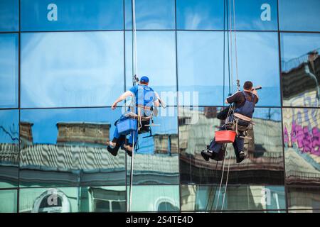 Due uomini finestra pulizia facciata del grattacielo Foto Stock
