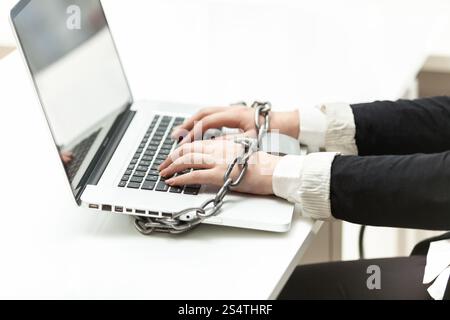 Primo piano della imprenditrice bloccato al laptop tramite la catena Foto Stock