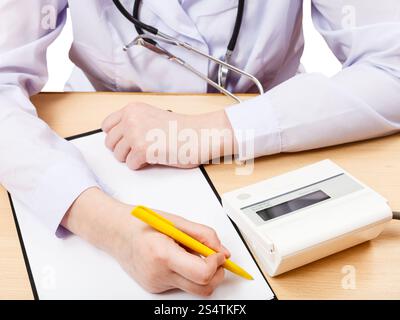 Medico misura la pressione del sangue durante la nomina isolato su bianco Foto Stock