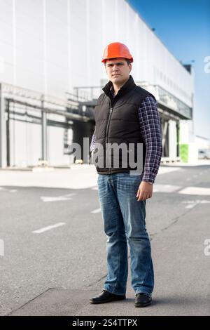 A piena lunghezza Ritratto di ingegnere bello in posa contro il grande magazzino Foto Stock