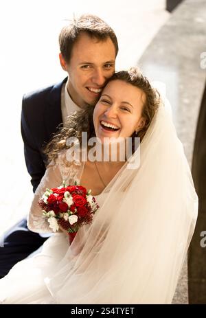 Ritratto di felice ridere sposa e lo sposo sulla strada al giorno di sole Foto Stock