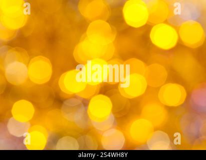 Abstract sfondo sfocato - giallo scintillanti luci di Natale bokeh di le ghirlande elettriche su albero di Natale Foto Stock