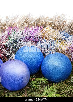 Blu e viola le decorazioni di Natale sul verde abete rosso di ramo di albero isolato su sfondo bianco Foto Stock
