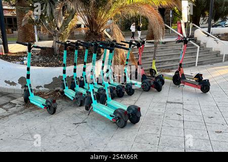 Una flotta di scooter elettrici (e-Scooters) parcheggiata a Costa Adeje, Tenerife, Isole Canarie, Spagna. 11 gennaio 2025. Foto Stock
