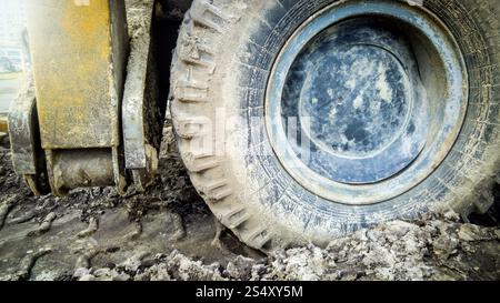 Primo piano della grande ruota di sporco di autocarro pesante sul sito di costruzione Foto Stock