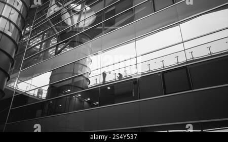 Immagine in bianco e nero di persone che riflette nel moderno edificio di vetro Foto Stock