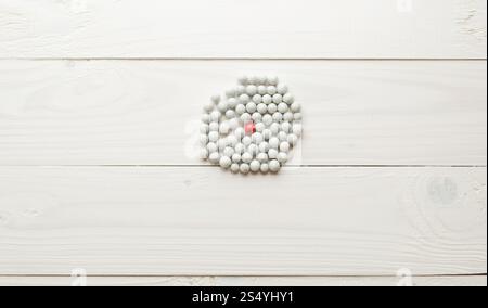 Immagine ravvicinata di una sfera rossa tra tante sfere bianche. Concetto di differenza Foto Stock