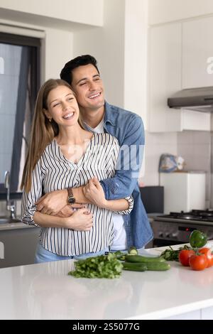 Felice e attraente coppia di sposi latini che si diverte a cucinare hobby Foto Stock