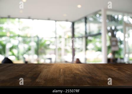 Tavolo vuoto di legno scuro di fronte a sfondo bokeh astratto sfocato del ristorante . può essere utilizzato per visualizzare o montaggio i vostri prodotti. Foto Stock
