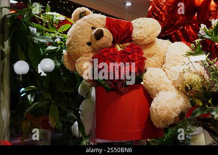 Un grande orsacchiotto con rose rosse per San Valentino Foto Stock