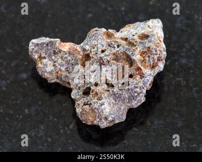 Le riprese in modalità macro di minerale naturale campione di roccia - pietra di basalto sul granito scuro dello sfondo Foto Stock