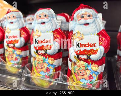 Bobruisk, Bielorussia - 4 gennaio 2025: Le colorate Santas di cioccolato sono allineate sullo scaffale di un negozio, deliziando gli acquirenti con i loro disegni natalizi. Ciascuna fig Foto Stock