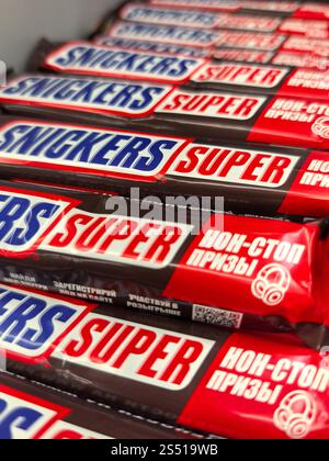 Bobruisk, Bielorussia - 4 gennaio 2025: File di vivaci bar di caramelle attendono gli amanti dello shopping nel corridoio delle caramelle. I coloratissimi involucri promettono un'esplosione di flav Foto Stock