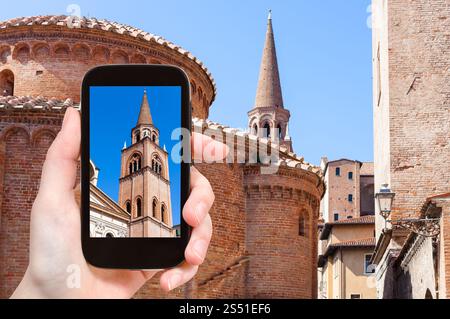 Concetto di viaggio - Torre delle fotografie turistiche e Rotonda di san lorenzo e Campanile della Basilica di Santandrea a Mantova in Italia su smartphone Foto Stock