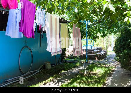 Stendibiancheria su funi al cortile della casa di campagna nella soleggiata giornata estiva in Kuban regione della Russia Foto Stock
