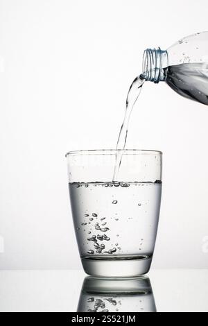 Primo piano di gocciolamento d'acqua dal vetro isolato su bianco. Primo piano di gocciolamento d'acqua dal vetro isolato su sfondo bianco Foto Stock