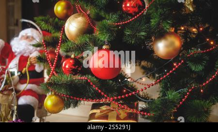 Foto tonificata dell'albero Chrismtas adornato e miniatura di Babbo Natale sulle slitte. Immagine tonificata dell'albero Chrismtas adornato e miniatura di Babbo Natale sulle slitte Foto Stock