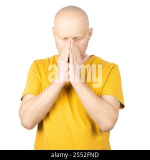 Un uomo calvo con una barba corta che indossa una t-shirt gialla posa su un semplice sfondo bianco. Foto Stock